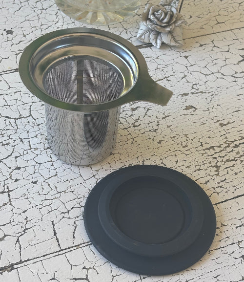 Stainless steel tea infuser with a black silicone lid 